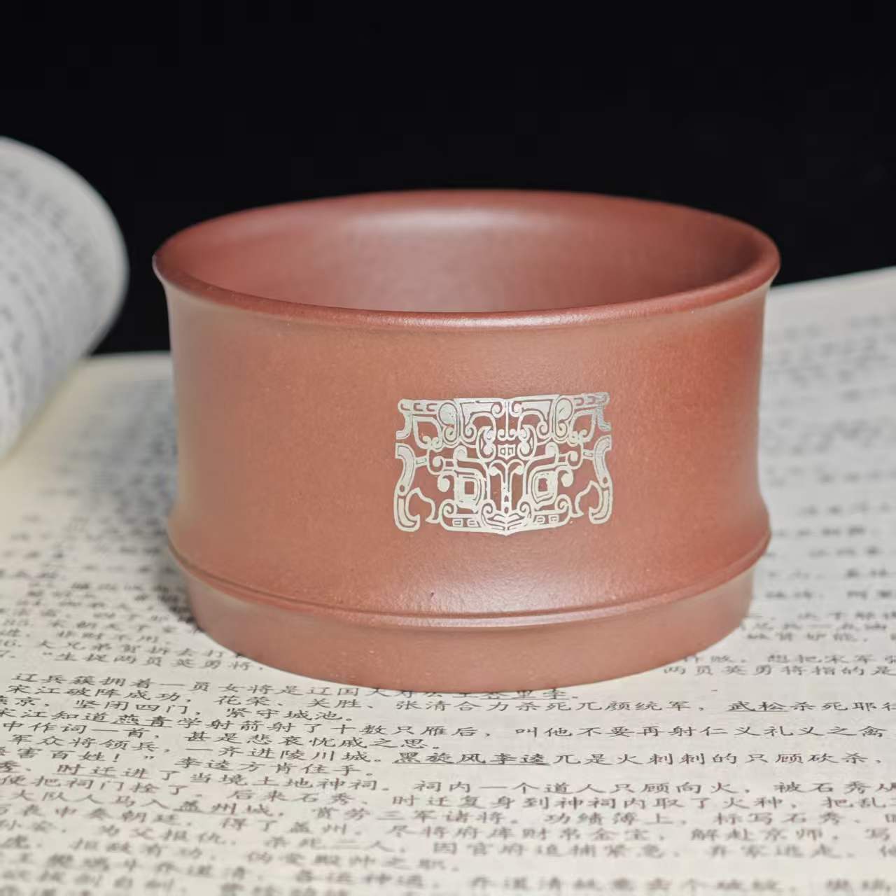 A purple clay jade inlaid with gold and silver engraving tea cup featuring the bronze human face pattern from Sanxingdui culture