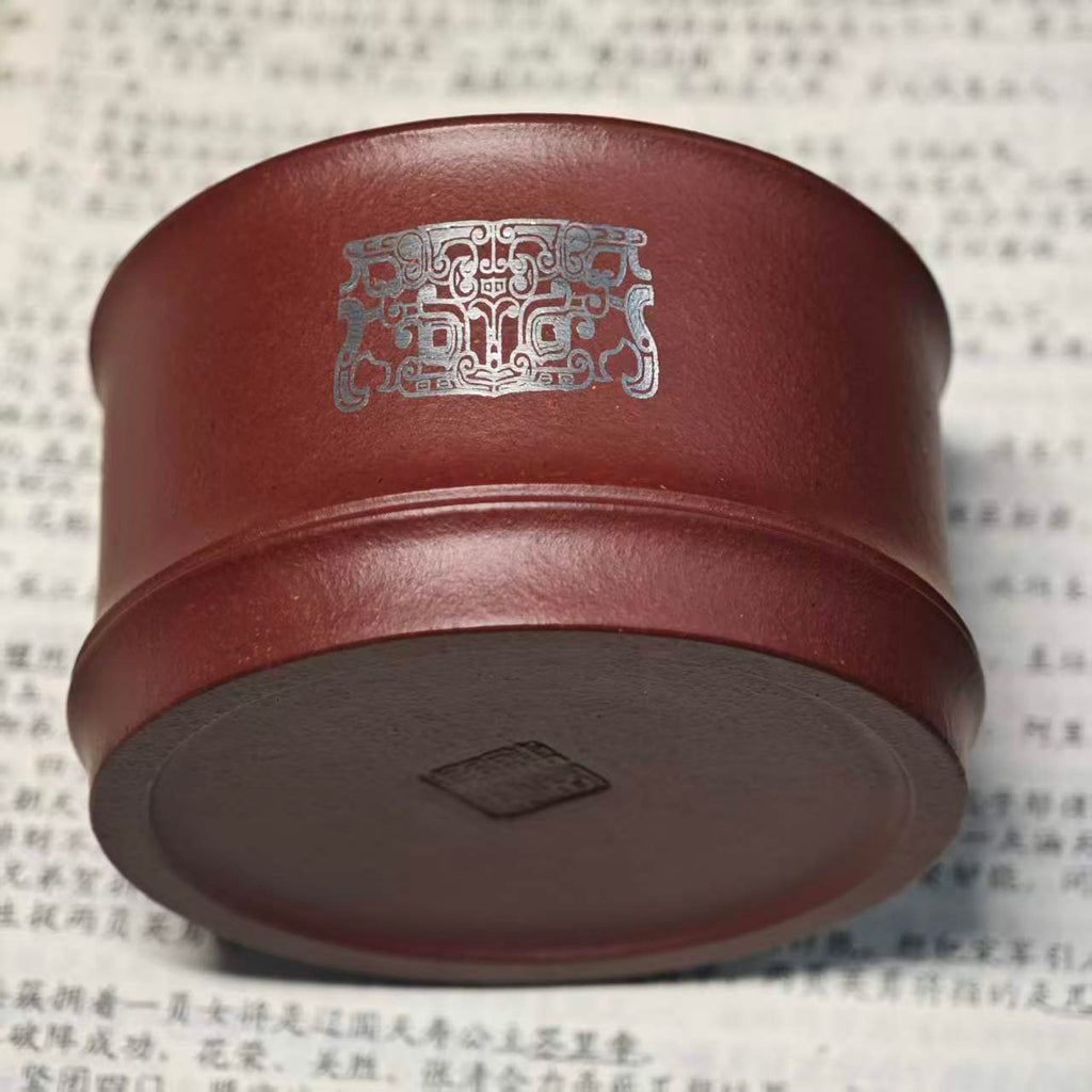 A purple clay jade inlaid with gold and silver engraving tea cup featuring the bronze human face pattern from Sanxingdui culture