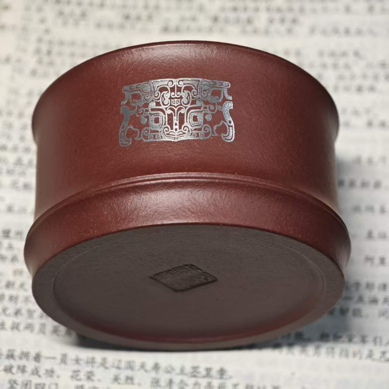 A purple clay jade inlaid with gold and silver engraving tea cup featuring the bronze human face pattern from Sanxingdui culture
