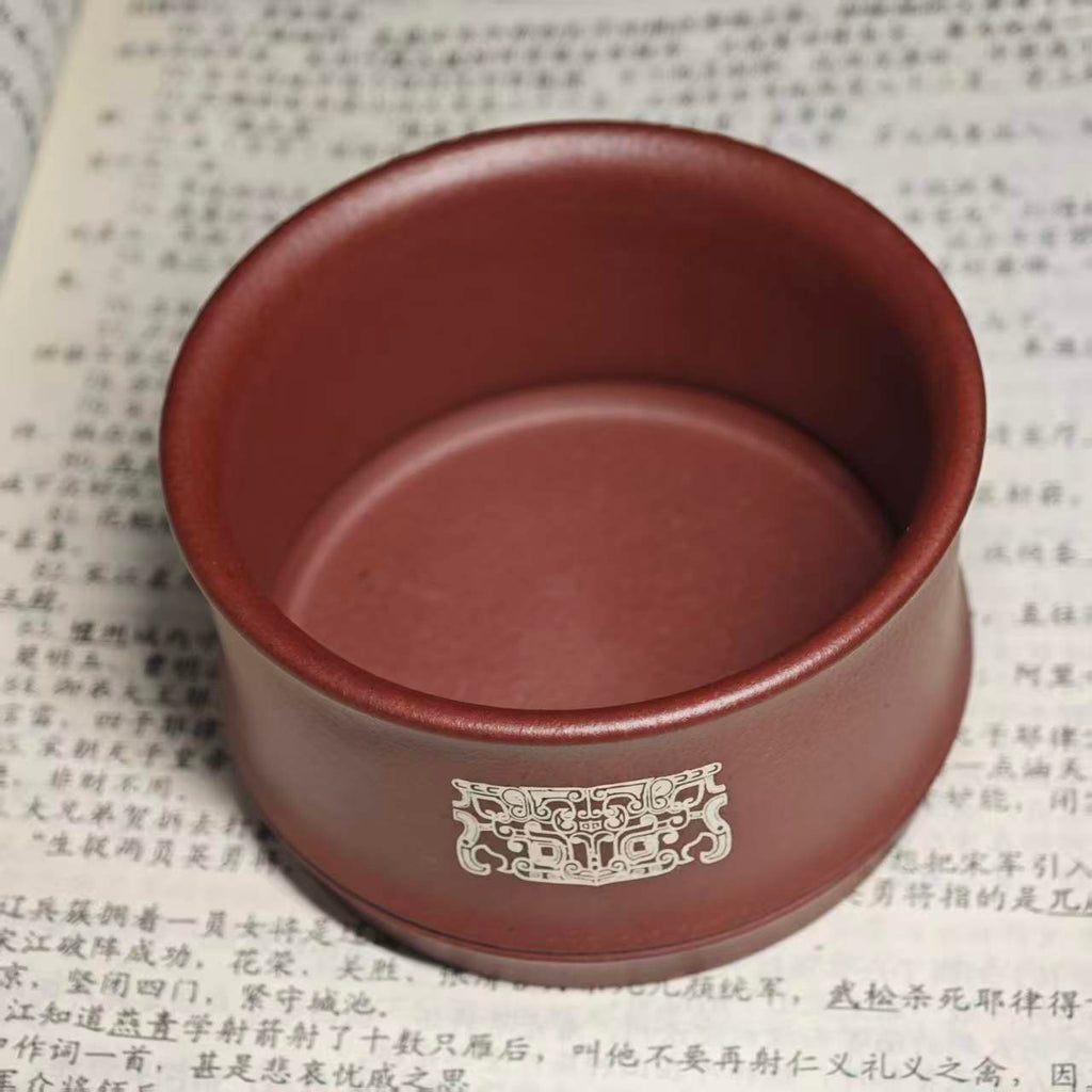 A purple clay jade inlaid with gold and silver engraving tea cup featuring the bronze human face pattern from Sanxingdui culture