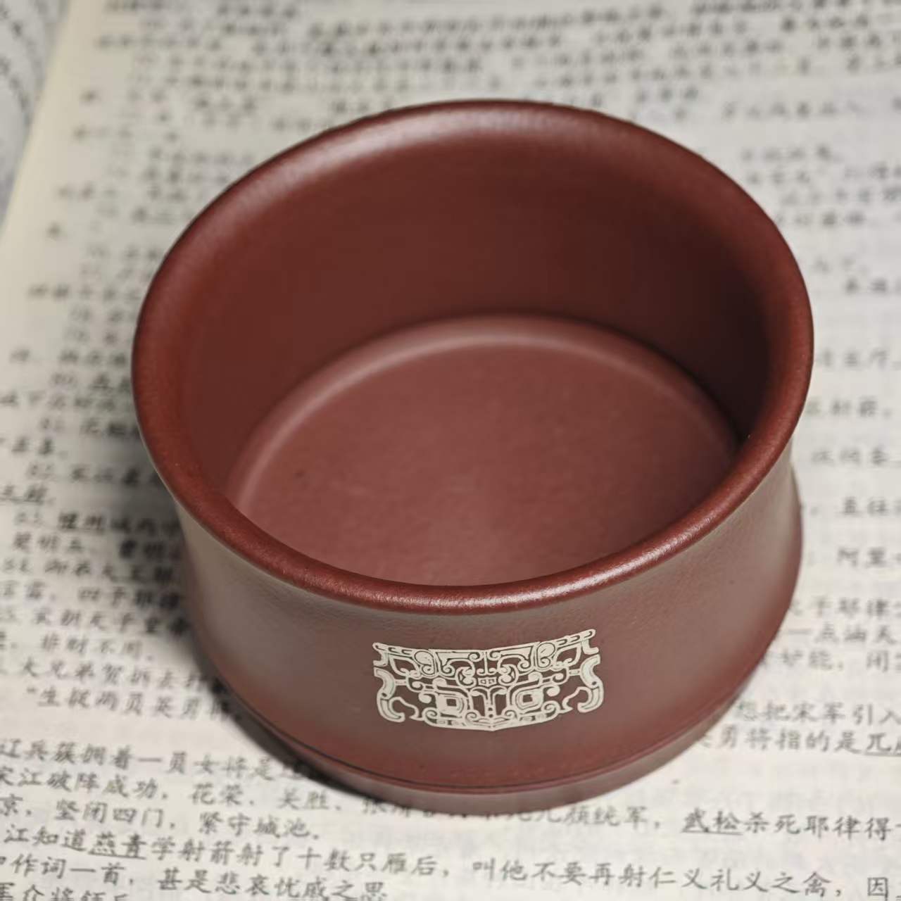 A purple clay jade inlaid with gold and silver engraving tea cup featuring the bronze human face pattern from Sanxingdui culture