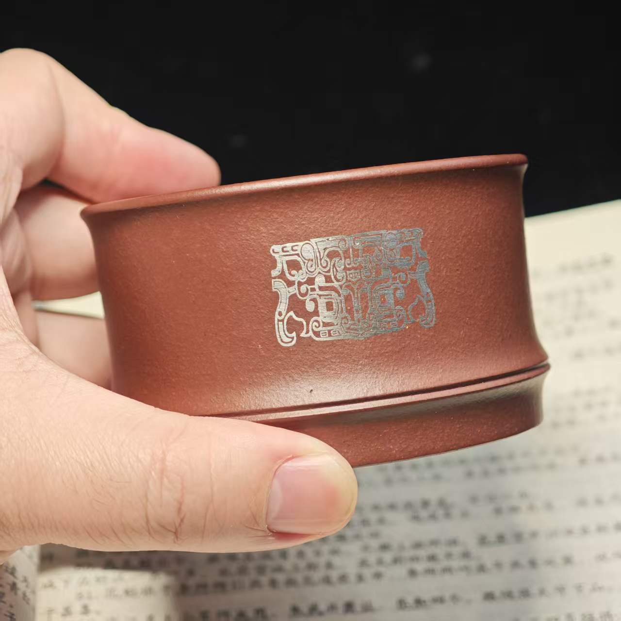 A purple clay jade inlaid with gold and silver engraving tea cup featuring the bronze human face pattern from Sanxingdui culture