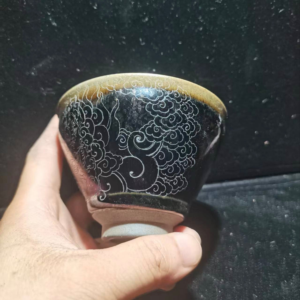 Dancing lion with water wave patterns carved on the base. Hand-carved Jianzhan tea cup