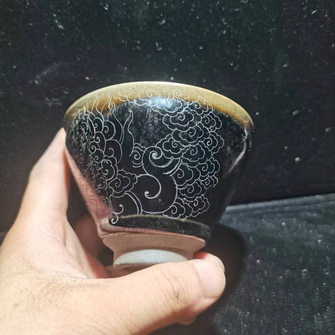 Dancing lion with water wave patterns carved on the base. Hand-carved Jianzhan tea cup