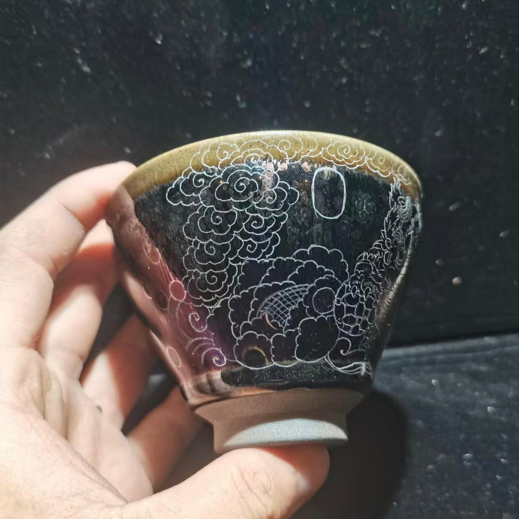 Dancing lion with water wave patterns carved on the base. Hand-carved Jianzhan tea cup