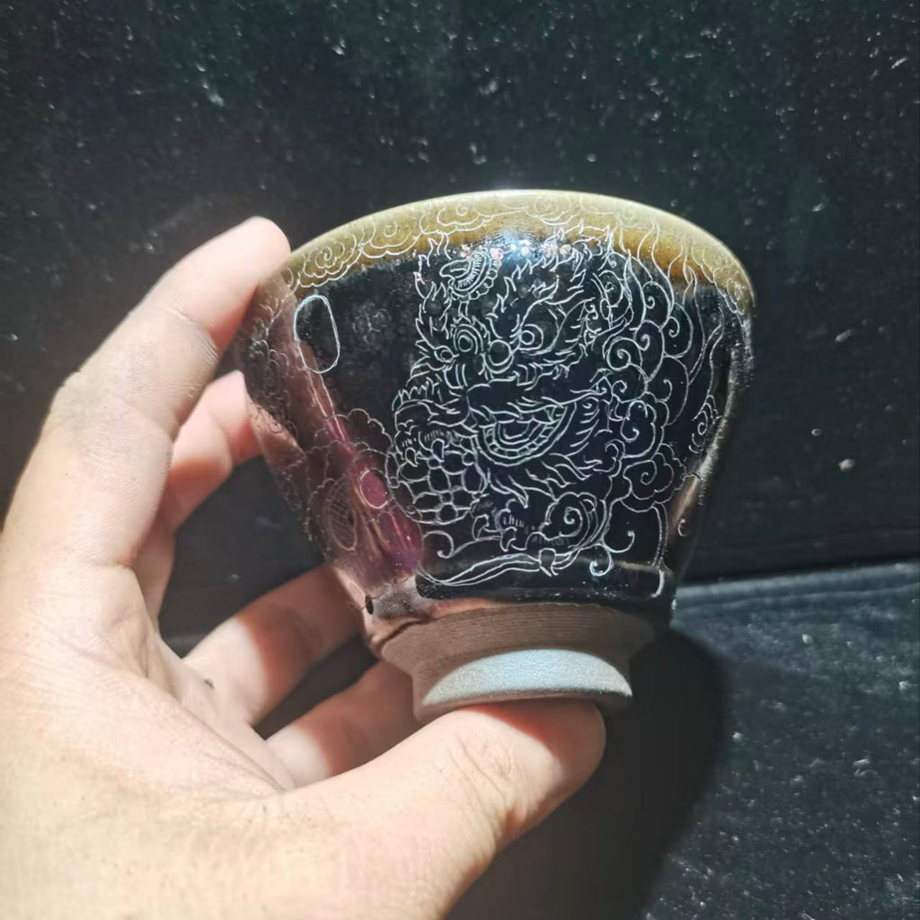 Dancing lion with water wave patterns carved on the base. Hand-carved Jianzhan tea cup
