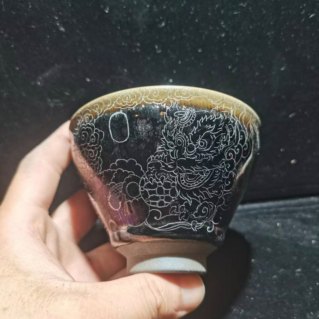 Dancing lion with water wave patterns carved on the base. Hand-carved Jianzhan tea cup
